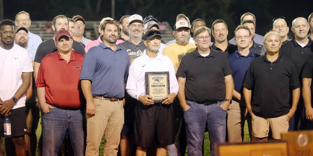 Former Carlisle Bison football coach James Clayton, center, was honored during a ceremony at halftime of the Carlisle-Lake Village football game Friday night at Fred C. Hardke Field. The field house is now called the James L. Clayton Fieldhouse. Photo: Mark Buffalo